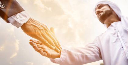 رجال إماراتي يصافح شخصاً آخراً