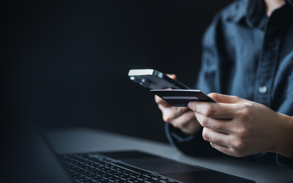شخص يحمل بطاقة ائتمان ويستخدم الحاسوب