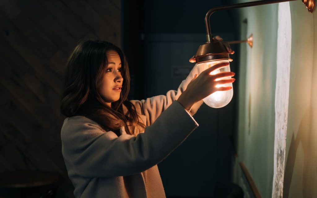 A girl setting up electric bulb in a new home