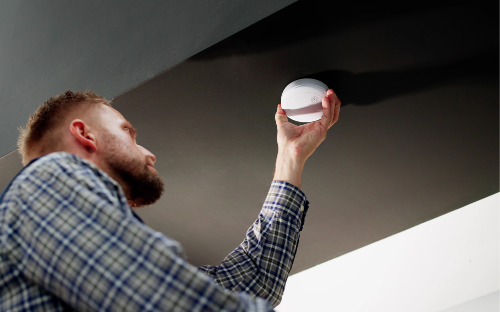 man checking smoke detector