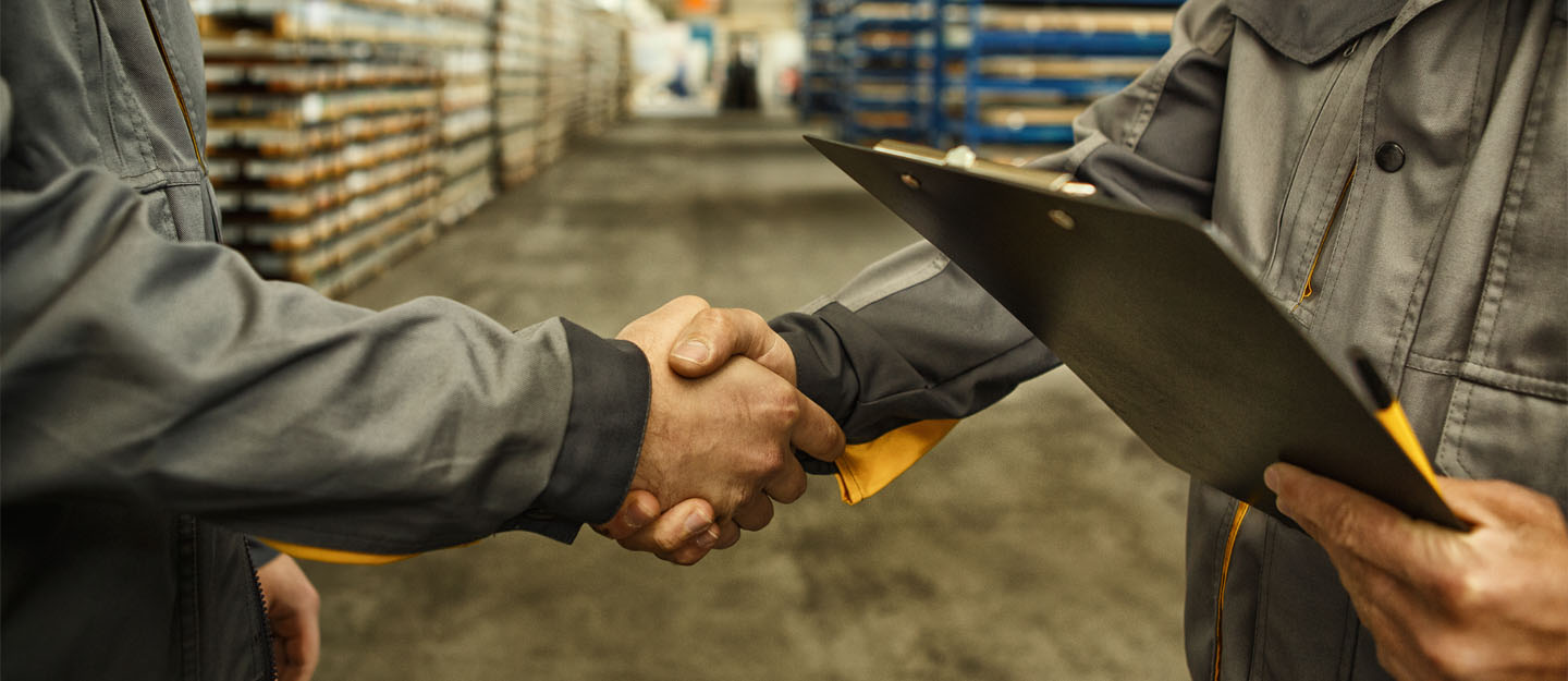 شخصان يصافحان بعضهما في مستودع