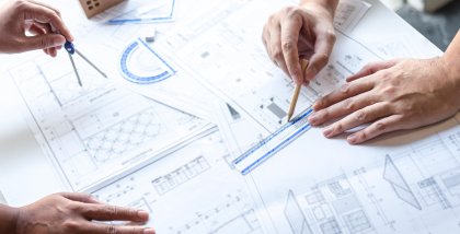 شخصان يرسمان مخططات هندسية على الورق