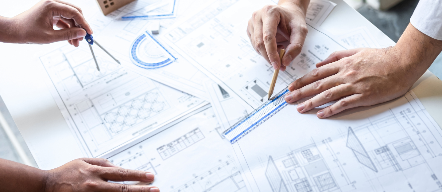 شخصان يرسمان مخططات هندسية على الورق