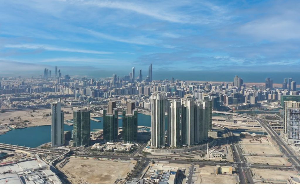 An aerial view of the Abu Dhabi skyline showcasing the modern residential clusters of Al Reem Island in the foreground.