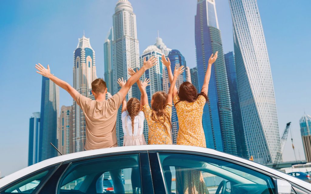 A happy family standing beside apartment buildings in a family-friendly community in Dubai