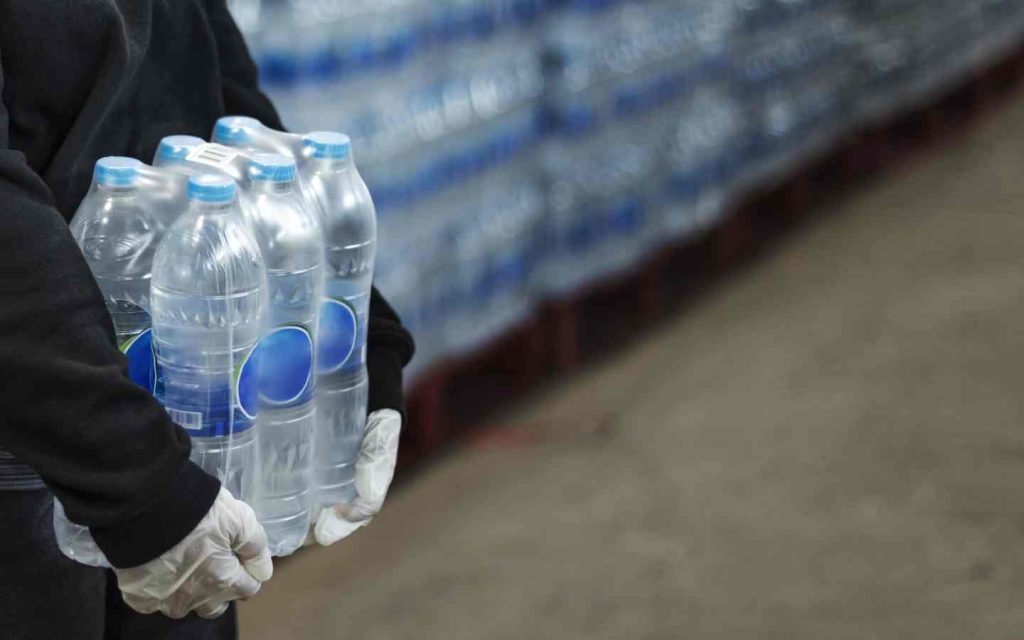 man carrying water bottles