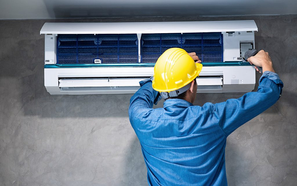 A man is repairing the AC during the summer
