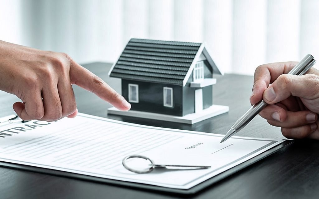 An individual pointing finger at the signature section in a contract. 