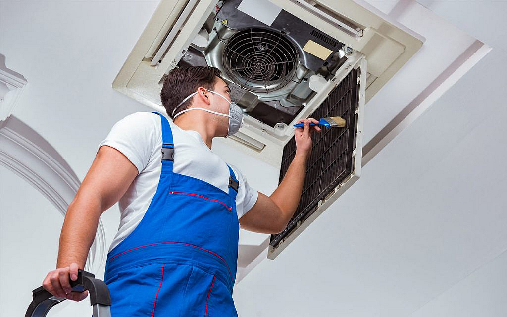 a workers is cleaning central AC