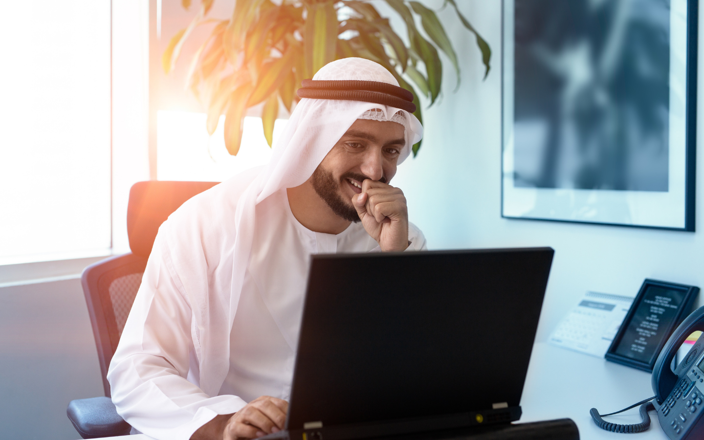 رجل إماراتي يستخدم جهاز حاسوب محمول