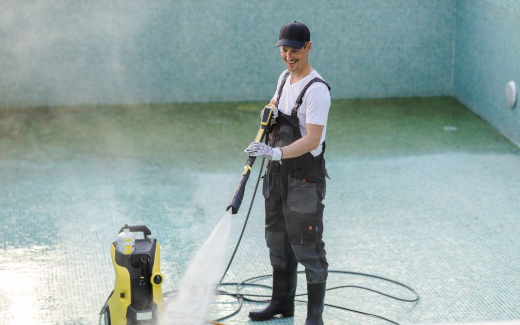 Pool technician cleaning a swimming pool in RAK