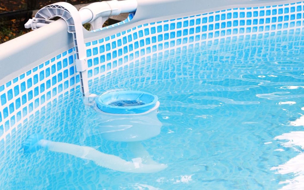 Pool maintenance experts in RAK cleaning pool with a skimmer 