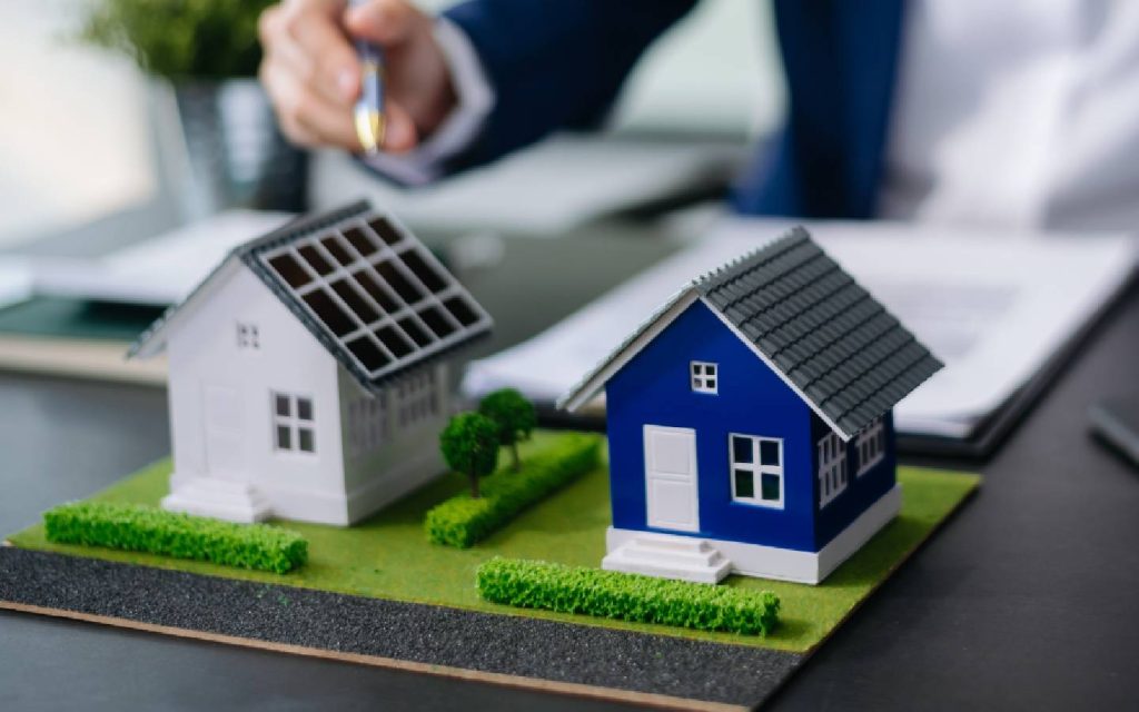 miniature houses side by side on a miniature land placed on a table